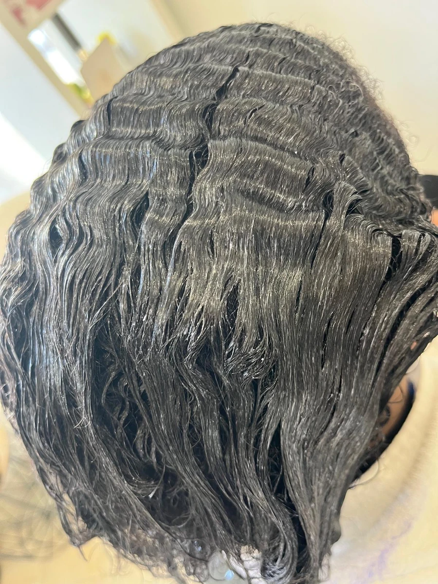 Cabelo afro com o produto da progressiva aplicado, durante o tratamento